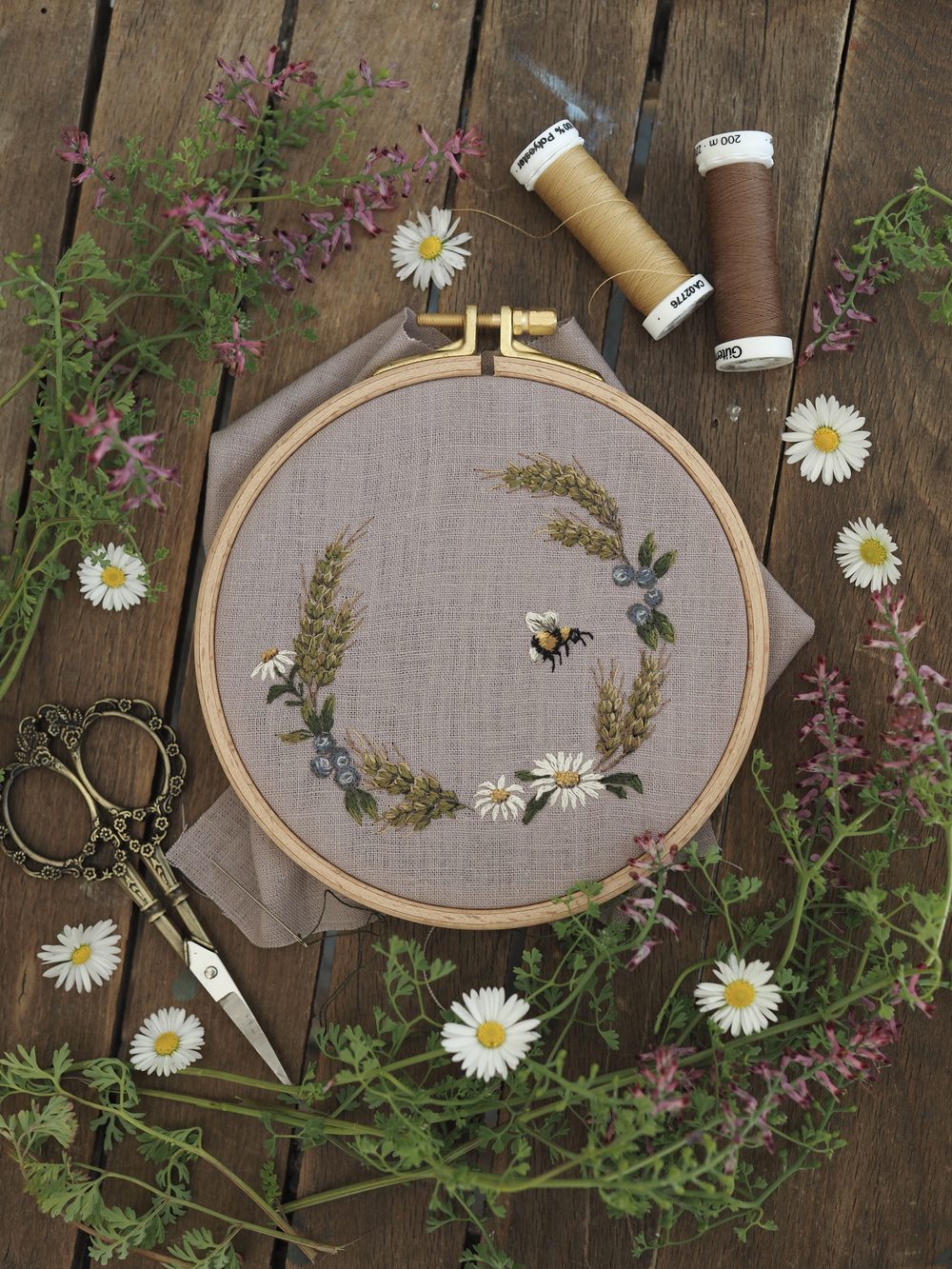 Gestickter Kranz aus Ähren und Blüten mit Hummel