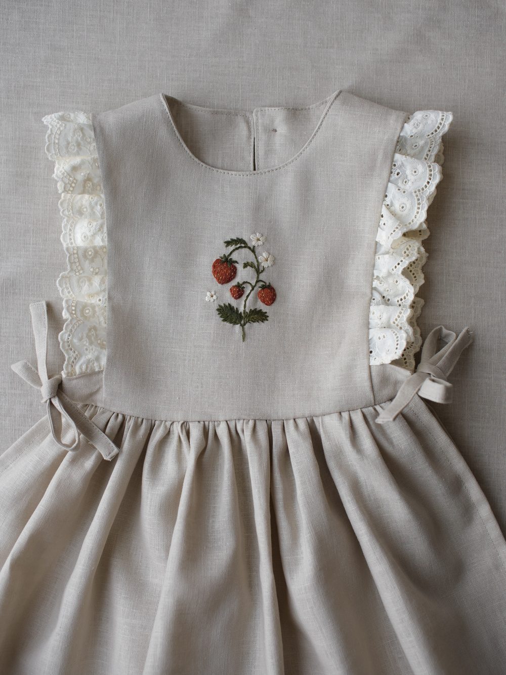 Helles Leinenkleid mit gestickter Erdbeerpflanze