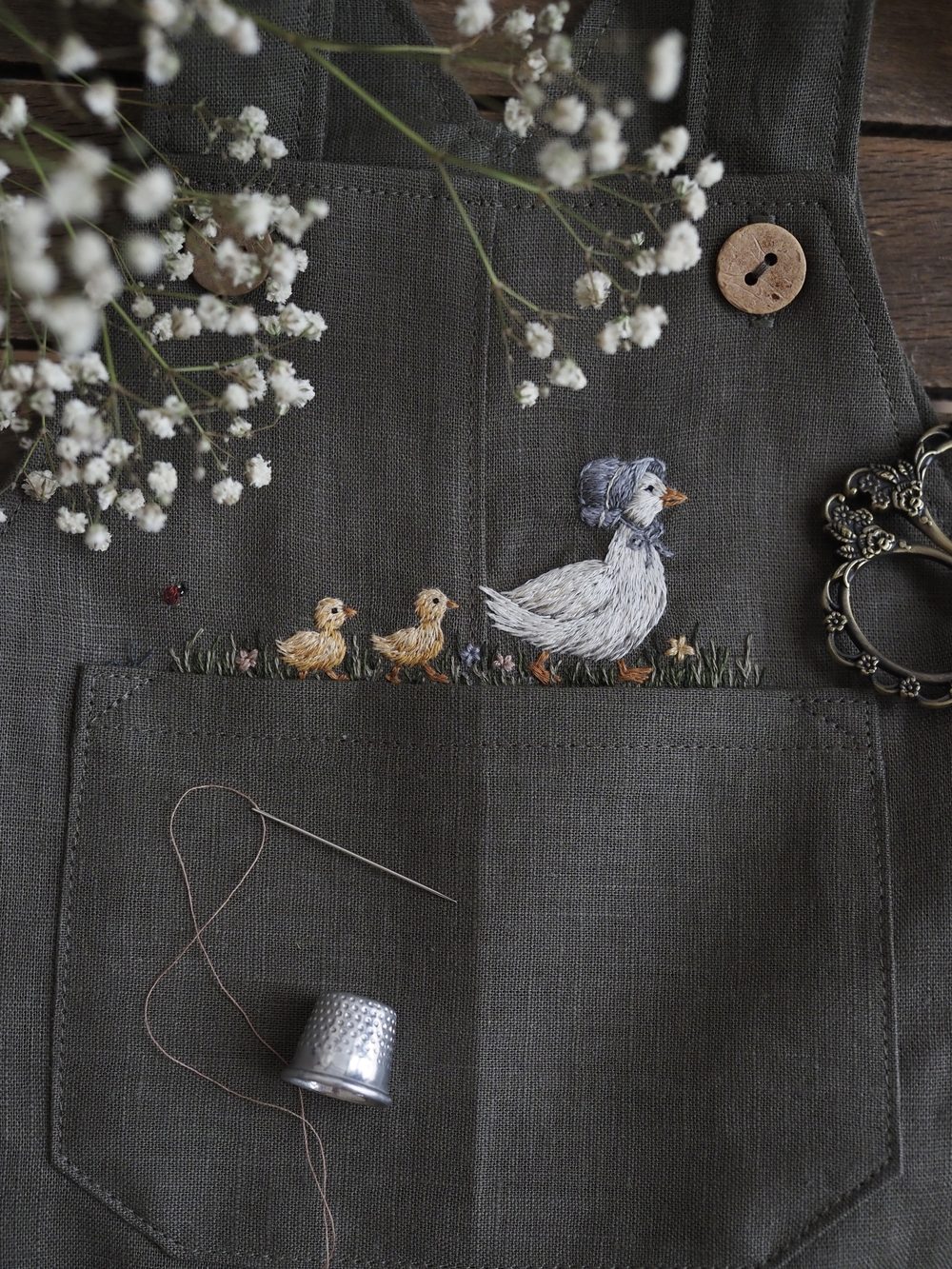 Dunkle Leinenlatzhose mit gestickter Gans und Küken