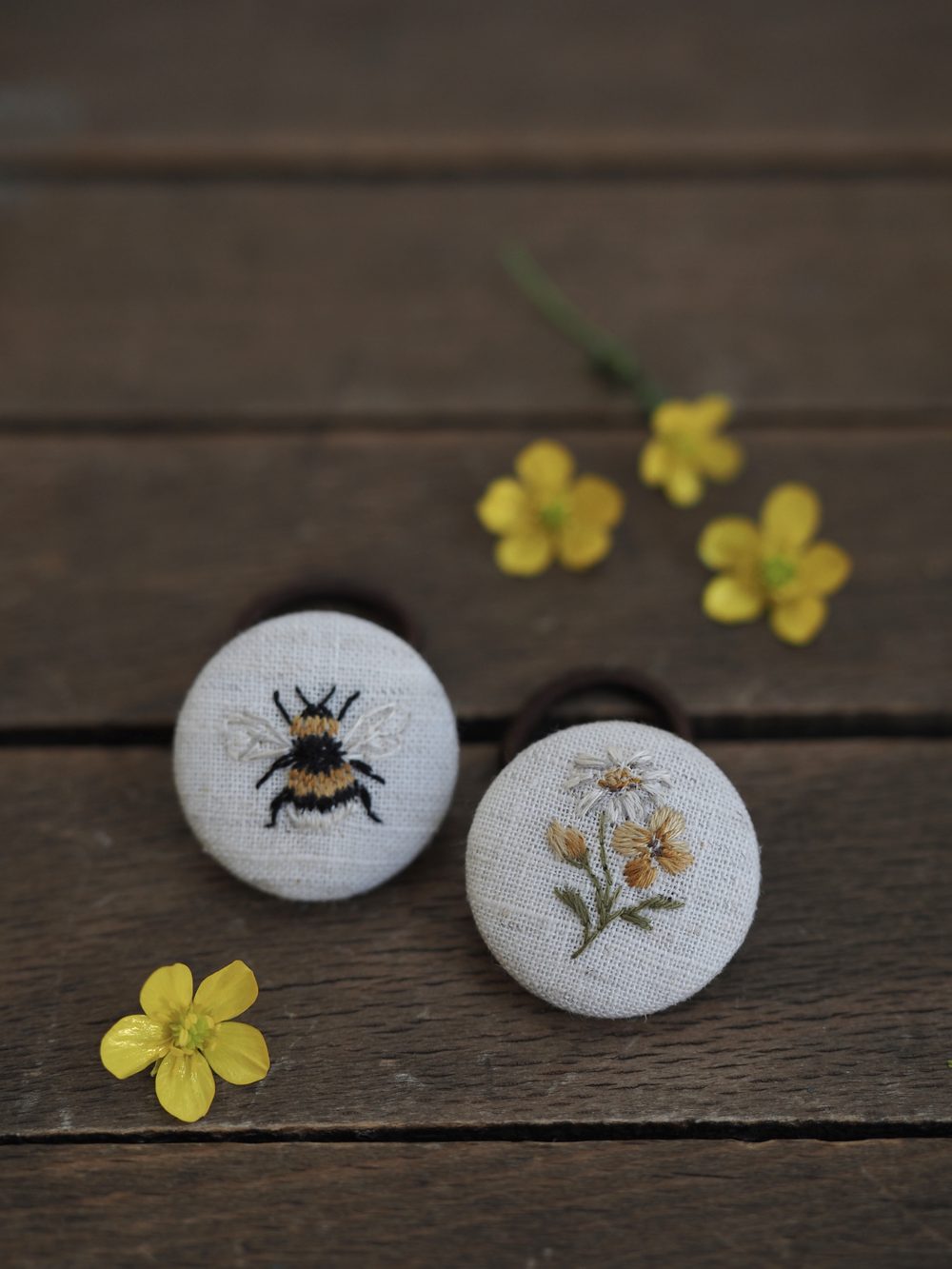 Bestickte Knöpfe mit Hummel und Blüte