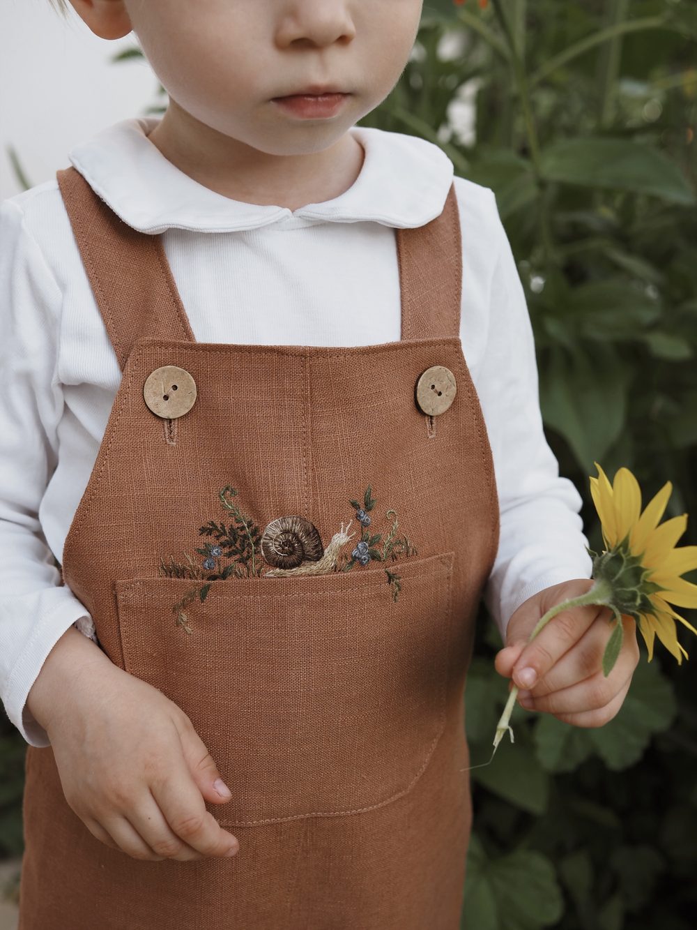 Rostrote Latzhose mit feiner Blumenstickerei