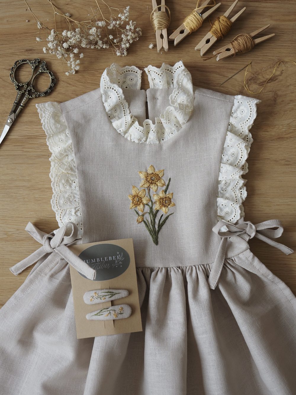 Helles Kleid mit Rüschen und gestickten Narzissen