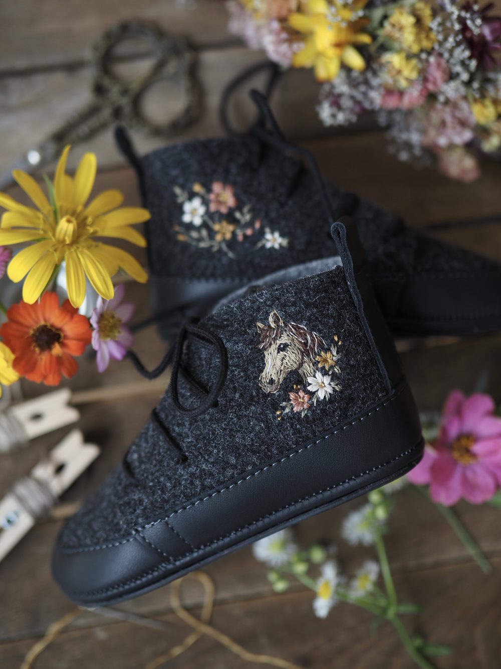 Dunkle Kinderschuhe mit gesticktem Pferd und Blüten