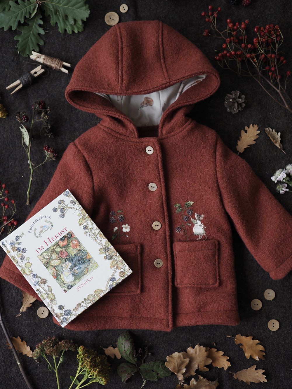 Roter Kapuzenmantel mit gestickter Maus und Bilderbuch