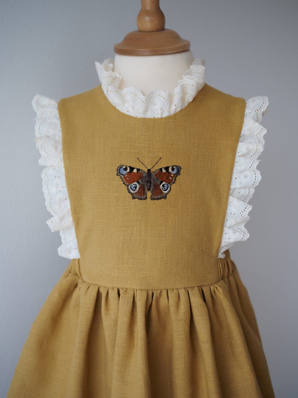 Senfgelbes Kleid mit gesticktem Schmetterling