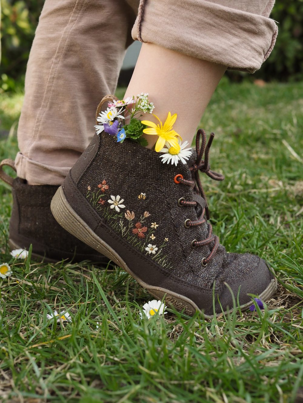Bestickte Filzschuhe mit Wiesenblumen im Gras