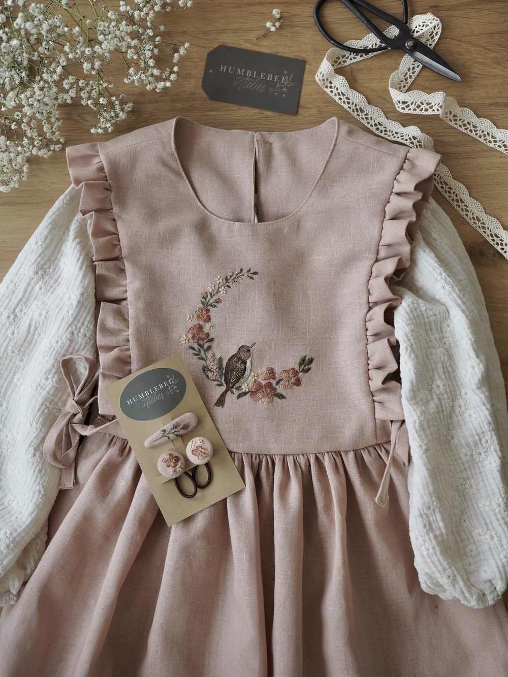 Rosa Kleid mit gesticktem Vogel im Blütenkranz