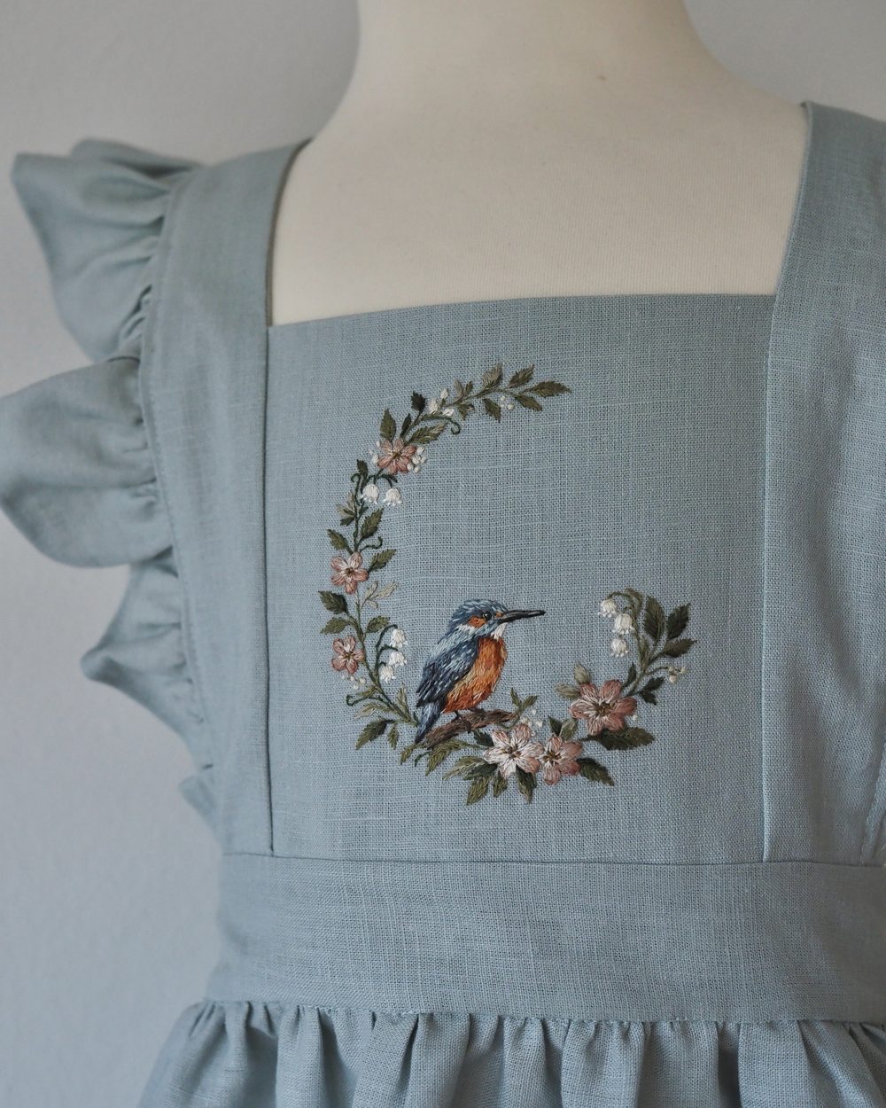 Hellblaues Leinenkleid mit gesticktem Vogel im Blütenkranz