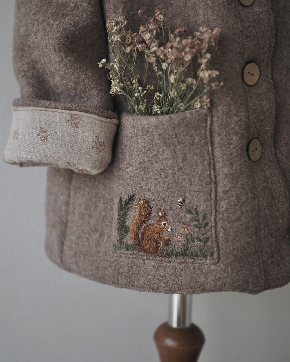 Wollmantel mit gesticktem Eichhörnchen an der Tasche